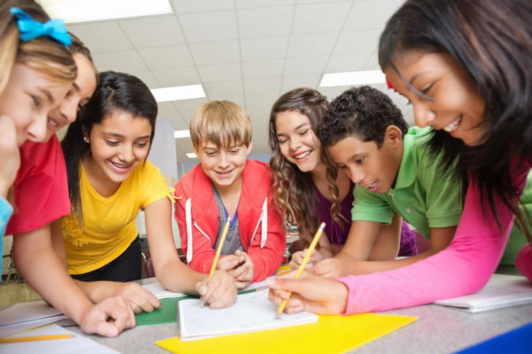 Students at classroom table doing an assignment together
